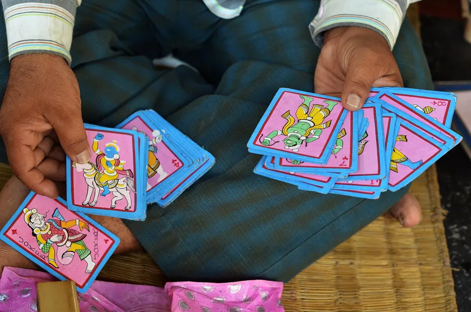 Rectangular ganjapa cards in a player's hands.